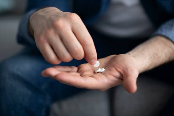 Person holding pills in hand